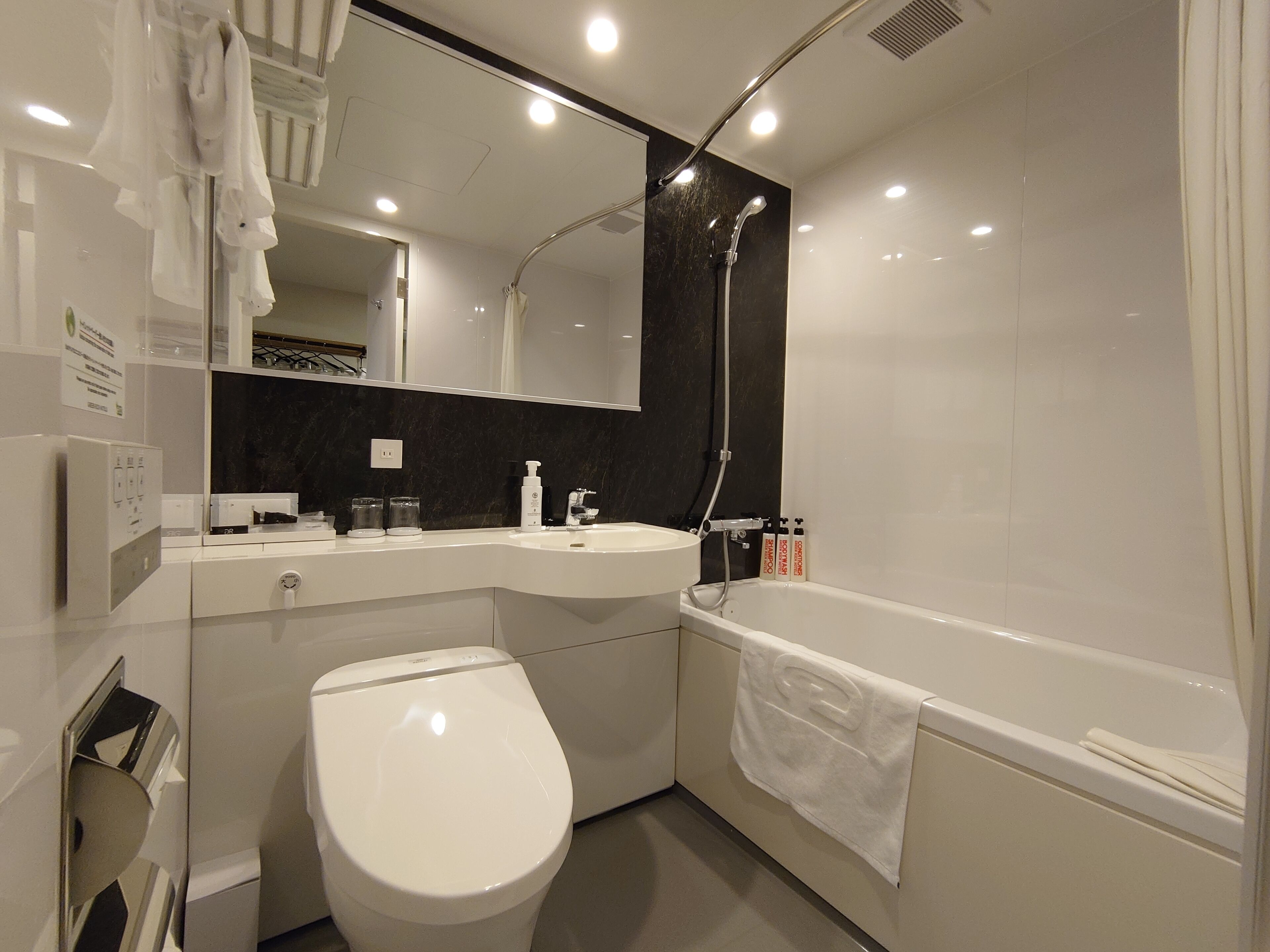 Un baño moderno con inodoro blanco, lavamanos y bañera.