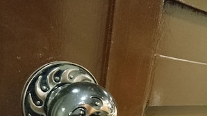 Eine Tür mit einem verzierten, metallenen Türknauf und einem Schlüsselanhänger.