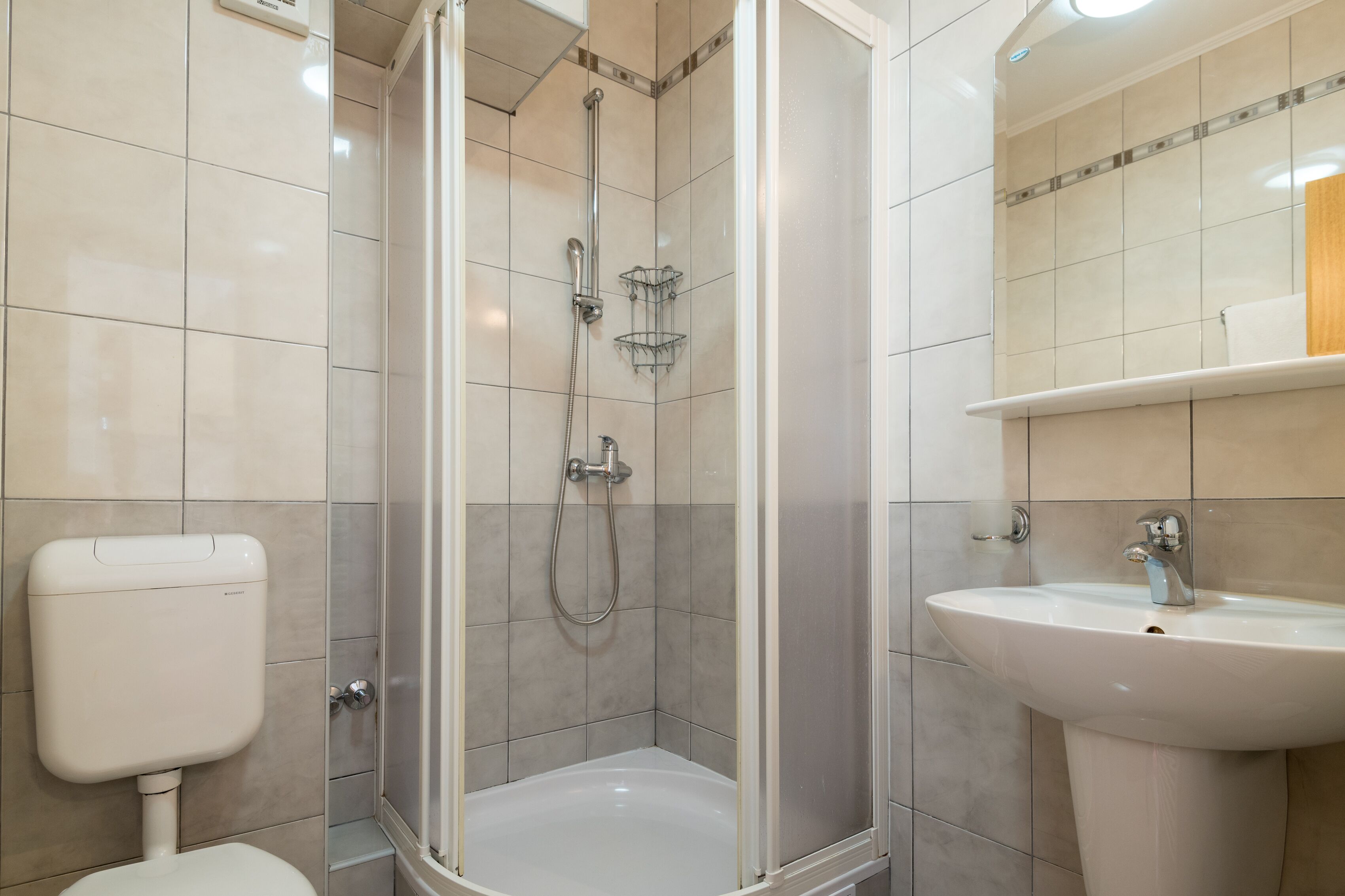 Ein Badezimmer mit Dusche, Toilette und Waschbecken.