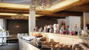 A breakfast buffet with various food items and decorative jars. - Giardino Bed & Breakfast (Silvaplana)