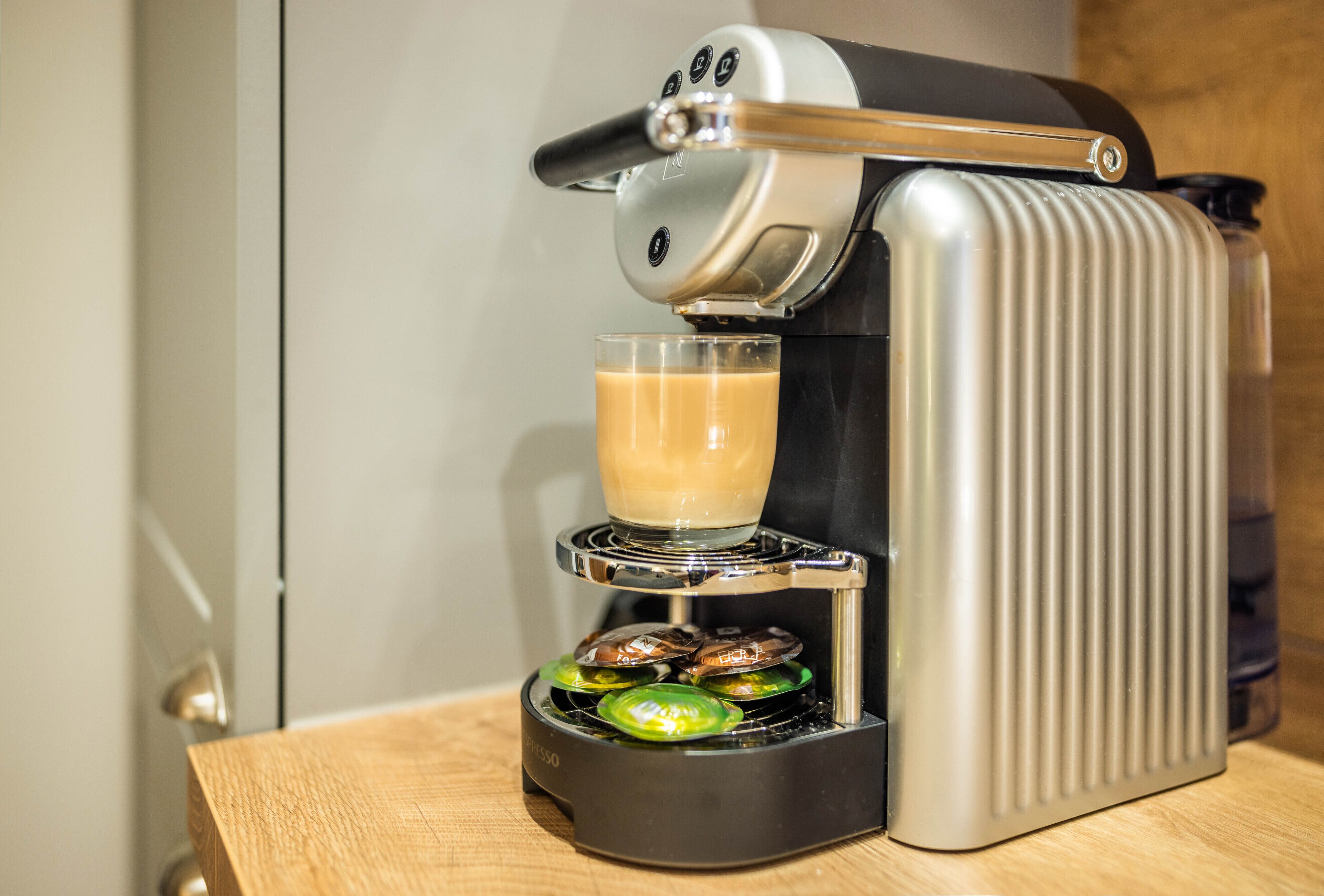 A coffee machine with a glass of coffee and a cup of espresso on its platform.