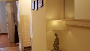 A hallway with a white console table, a lamp, and framed pictures on the wall. - Kibilù - Piazzale Ghirlandaio (Milan)