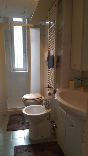 A bathroom with a toilet, bidet, and sink.