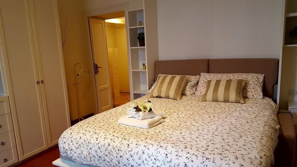 A bedroom with a bed, a wardrobe, and a shelving unit. - Kibilù - Piazzale Ghirlandaio (Milan)