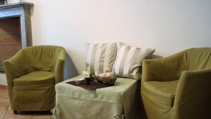 A cozy living room with two green armchairs and a small table with a basket of bread and a cup. - Kibilù - Piazzale Ghirlandaio (Milan)