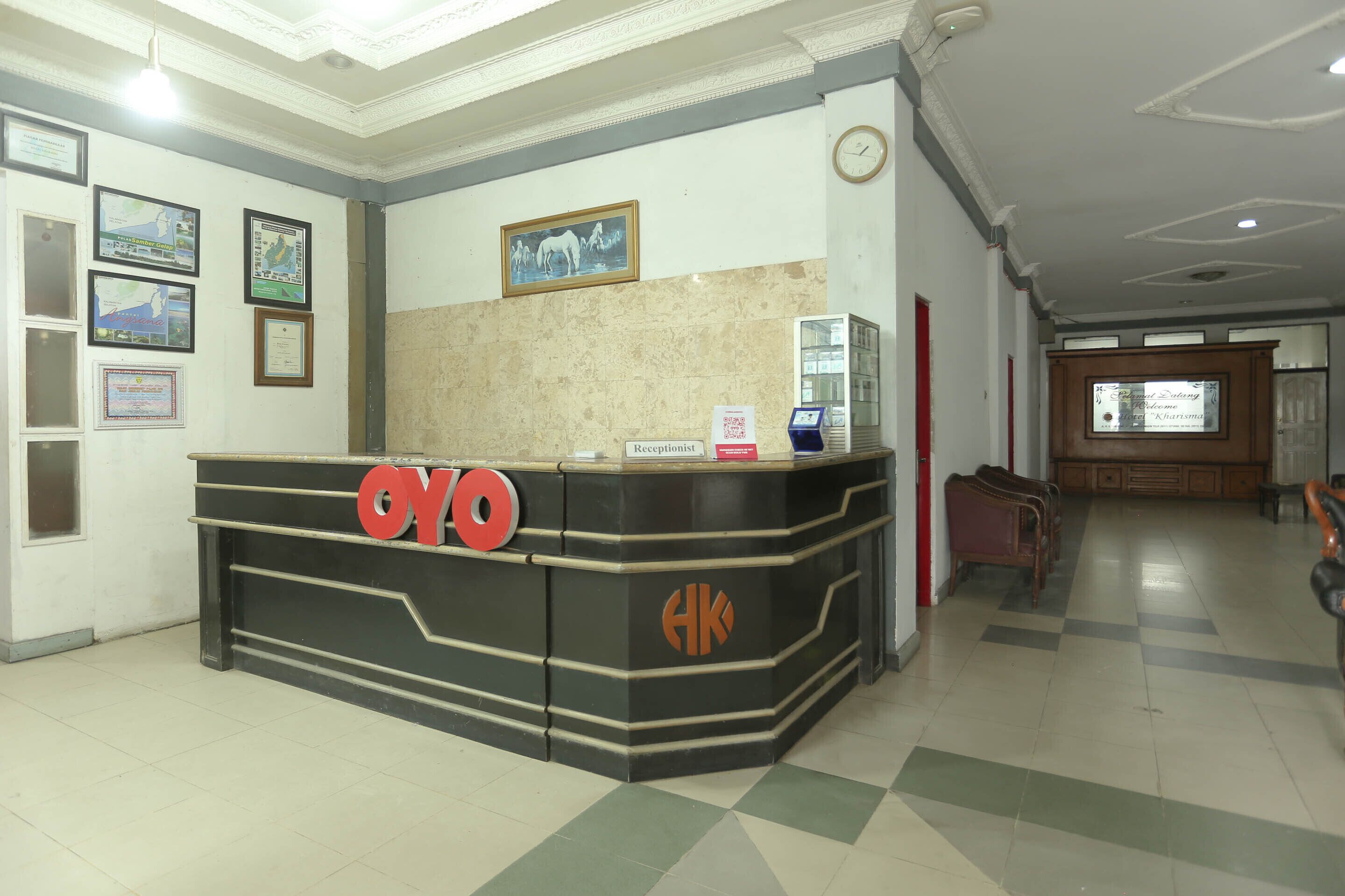 A reception desk with a clock, framed certificates, and a seating area with chairs.
