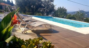 A poolside area with lounge chairs and a view of the pool.