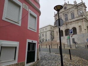 A building with a red facade, a black gate, and a street lamp.