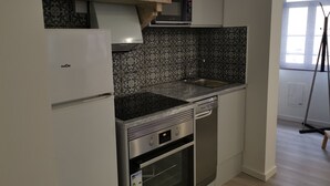 A compact kitchen with a built-in microwave, oven, and dishwasher.
