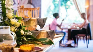Une scène de restaurant avec une table dressée pour deux personnes, comprenant un panier, une carafe et une assiette avec de la nourriture.