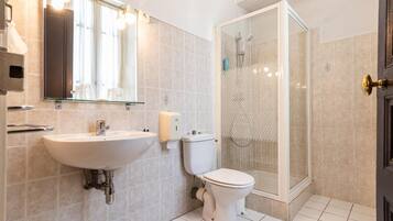 Une salle de bain moderne avec un lavabo, des toilettes et une douche à parois de verre.