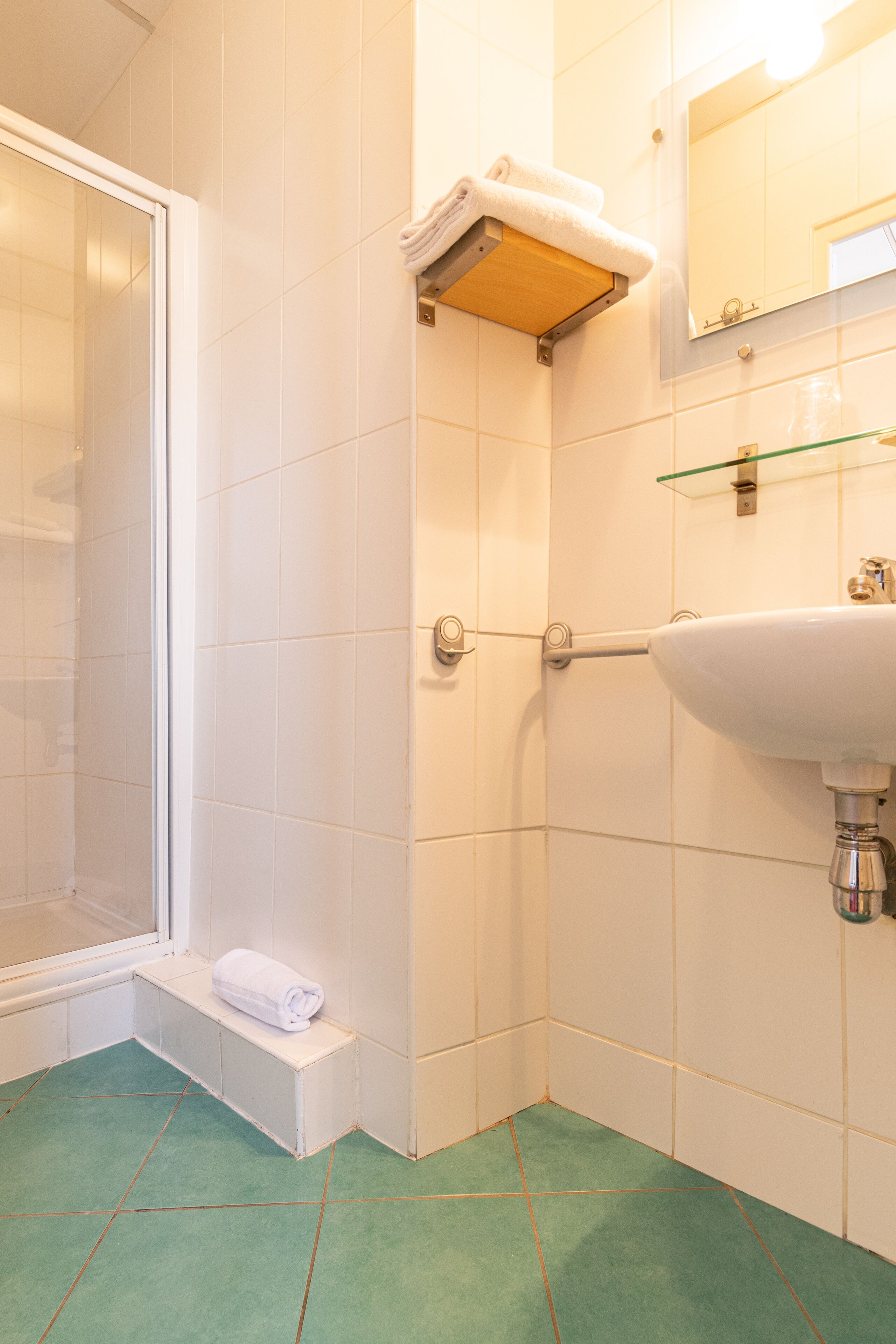 A bathroom with a shower, a sink, and a mirror.