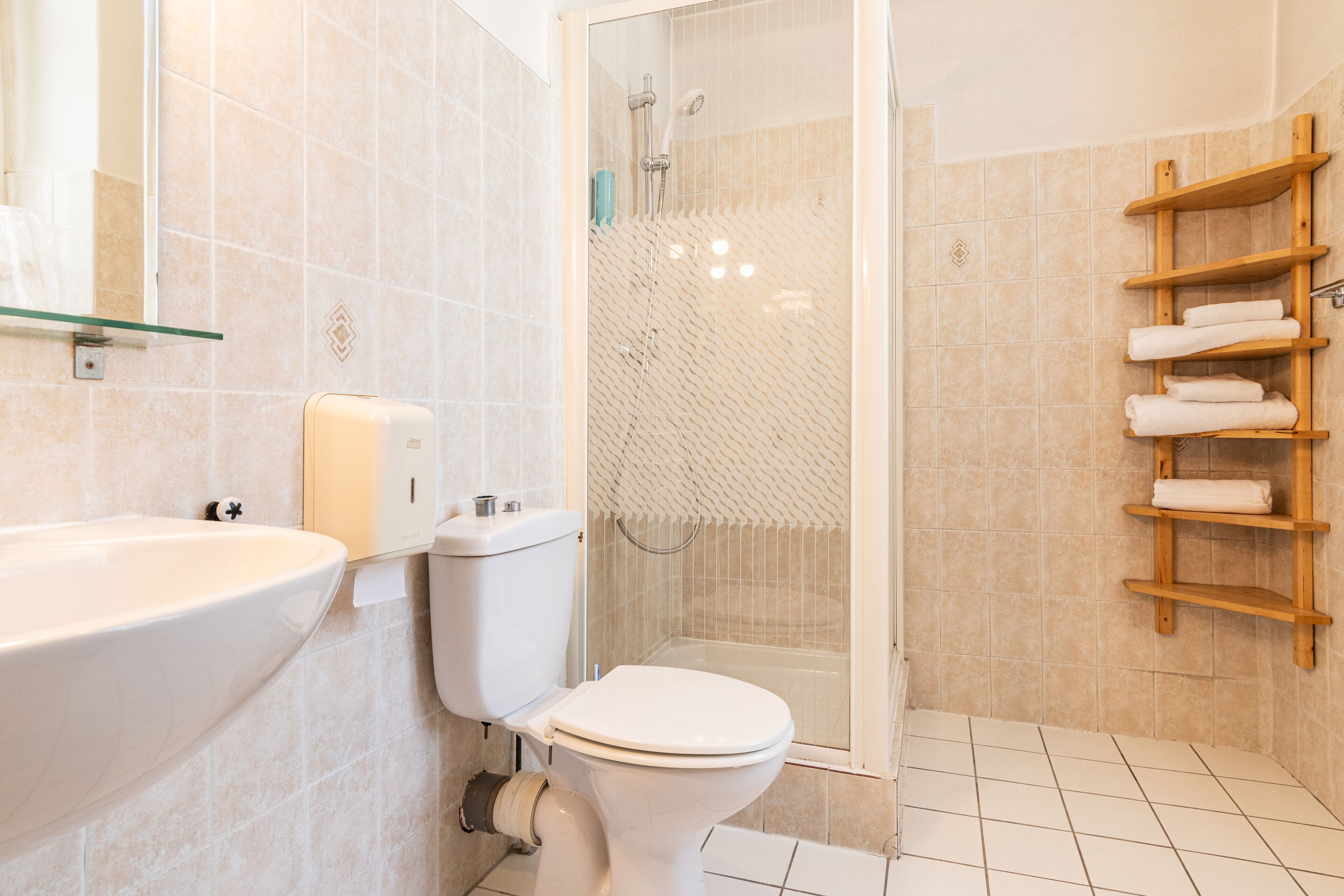 Un baño moderno con inodoro, lavamanos y ducha.