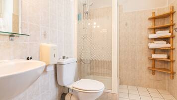 Un baño moderno con inodoro, lavamanos y ducha.