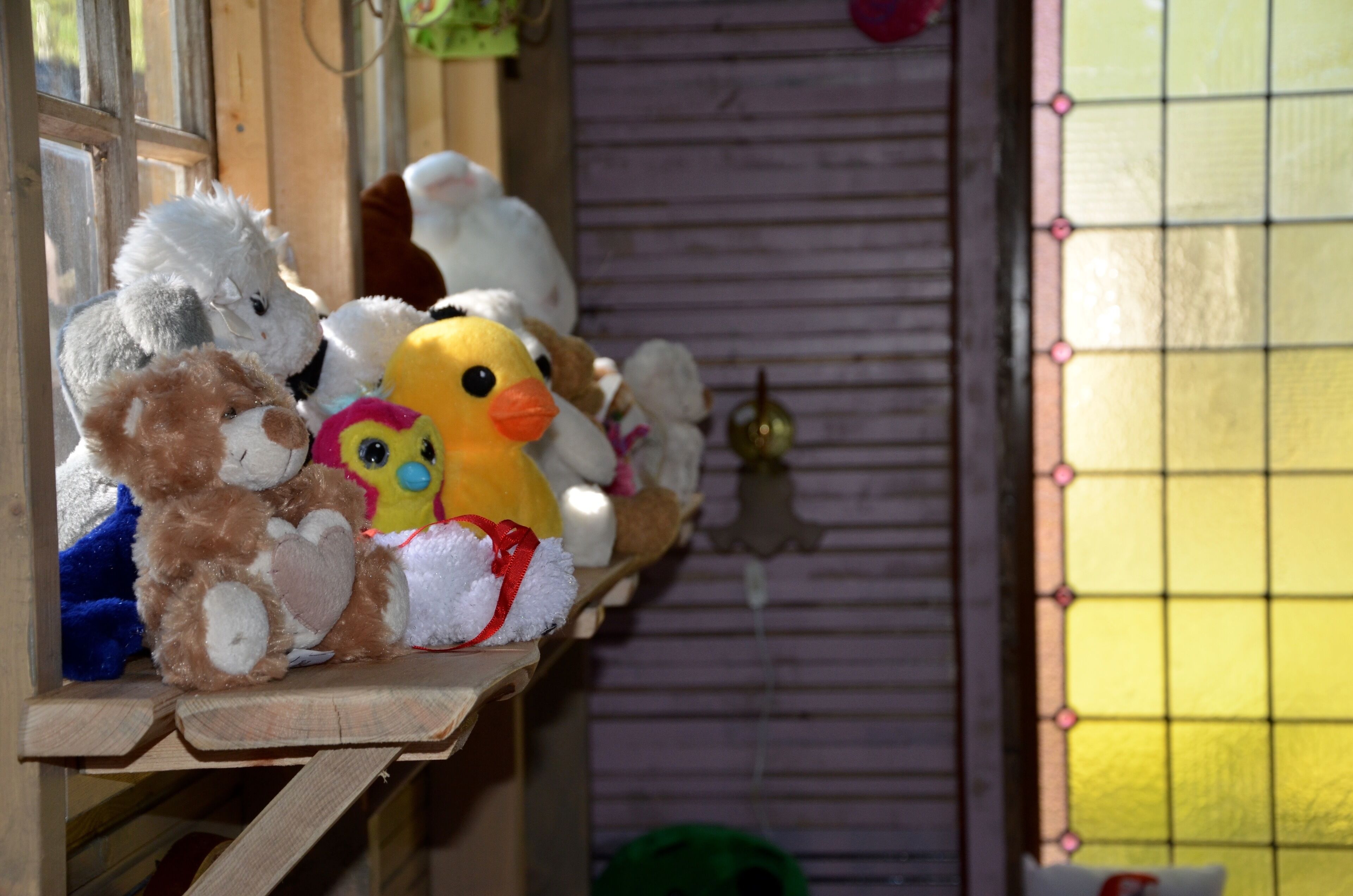 A shelf with various stuffed animals and a small bell.