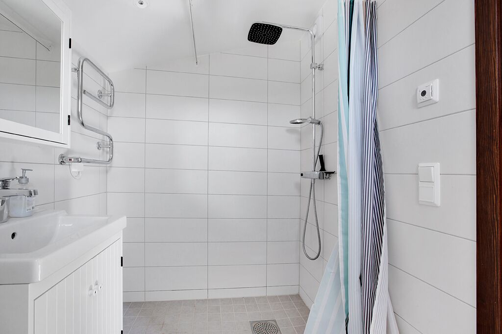 A modern bathroom with a shower, a sink, and a mirror.