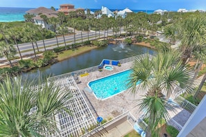 Ein Resort mit Schwimmbad, umgeben von Palmen, einem Wasserspiel und Blick auf den Ozean.