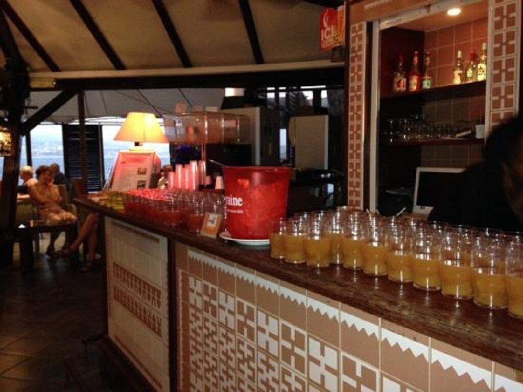 Un espace bar avec un comptoir, des verres et un seau rouge.