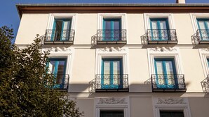 A building with multiple windows and balconies, featuring decorative moldings and shutters. - Colectia Stays Atocha (Madrid)