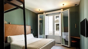 A bedroom with a bed, a wardrobe, a television, and a sliding door to a balcony. - Colectia Stays Atocha (Madrid)
