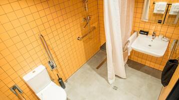 Un baño con inodoro blanco, lavamanos y ducha con puerta de cristal.