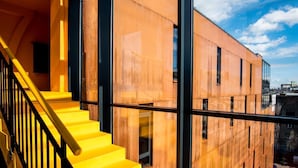 Un edificio moderno con una escalera amarilla y ventanas amplias.
