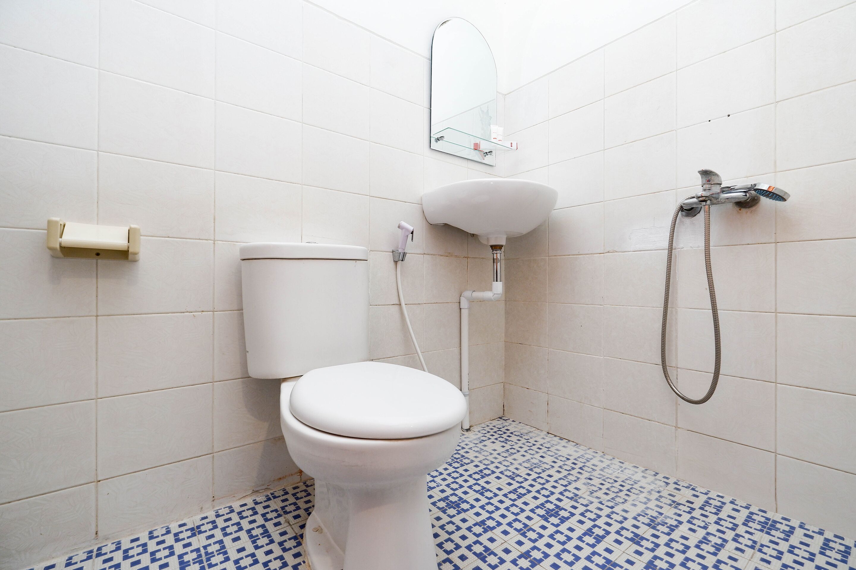 Une salle de bain avec des toilettes, un lavabo et une douche.