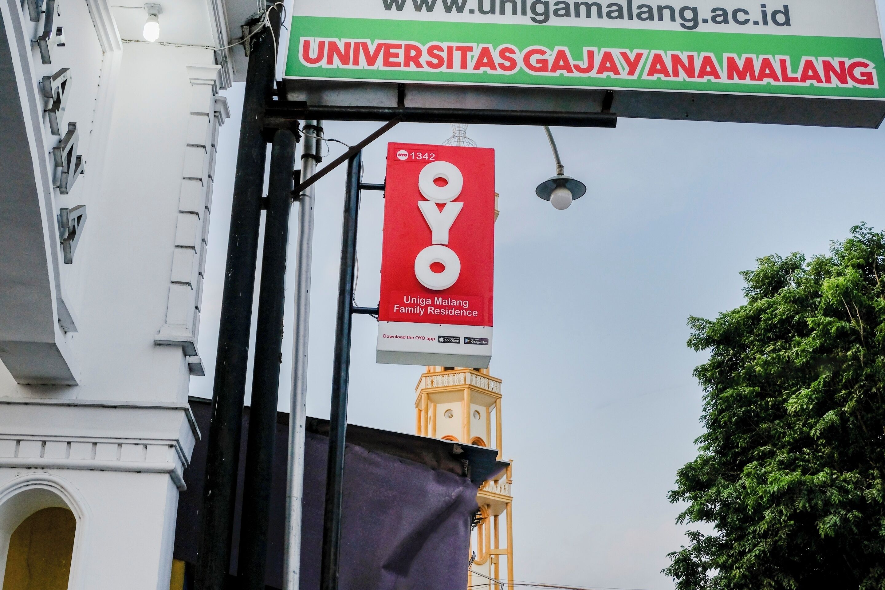 A sign for Universitas Gajah Ana Malang with a prominent OYO logo.
