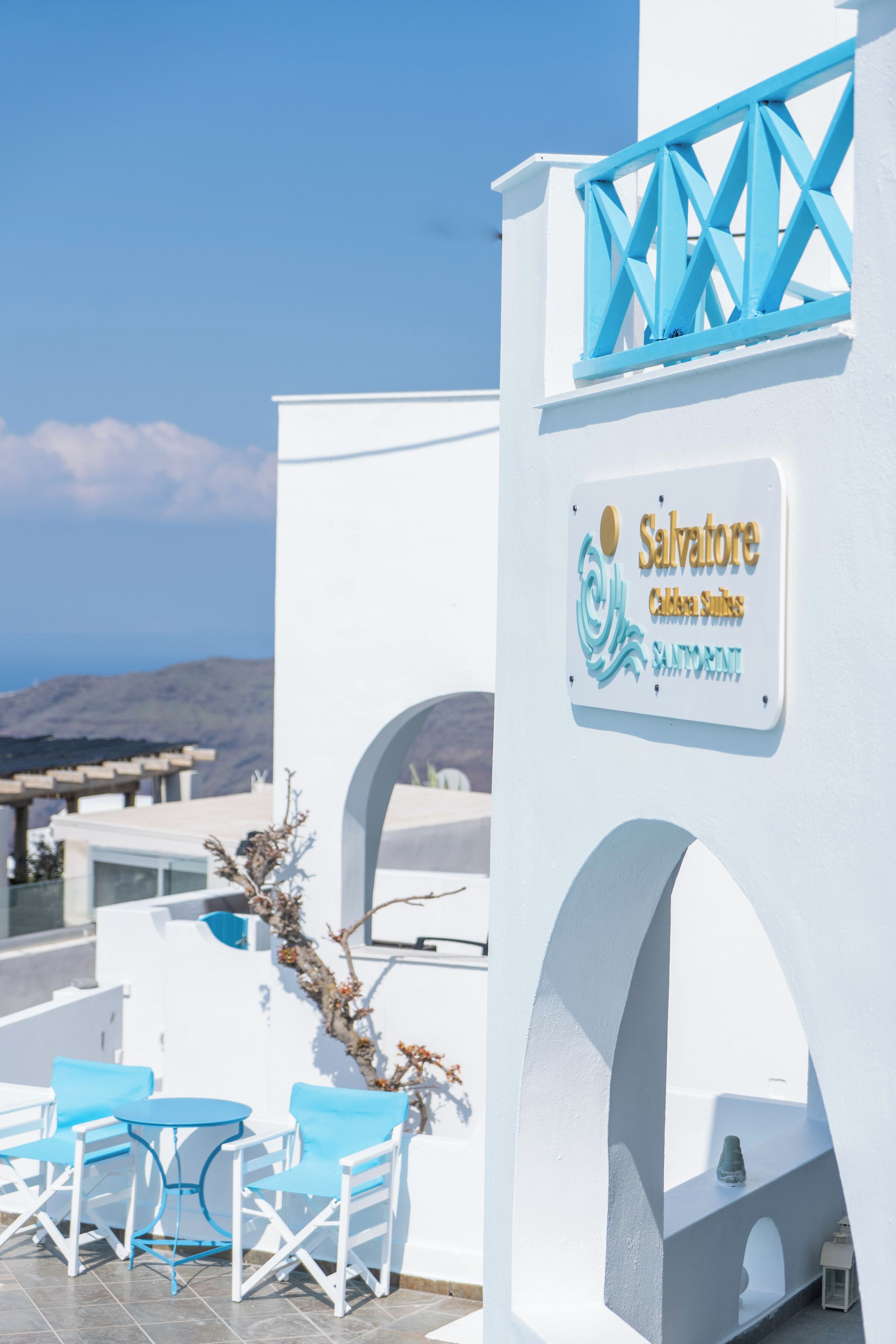 Un edificio blanco con un cartel que dice 'Salvatore Calareski Suites' y vista al mar.