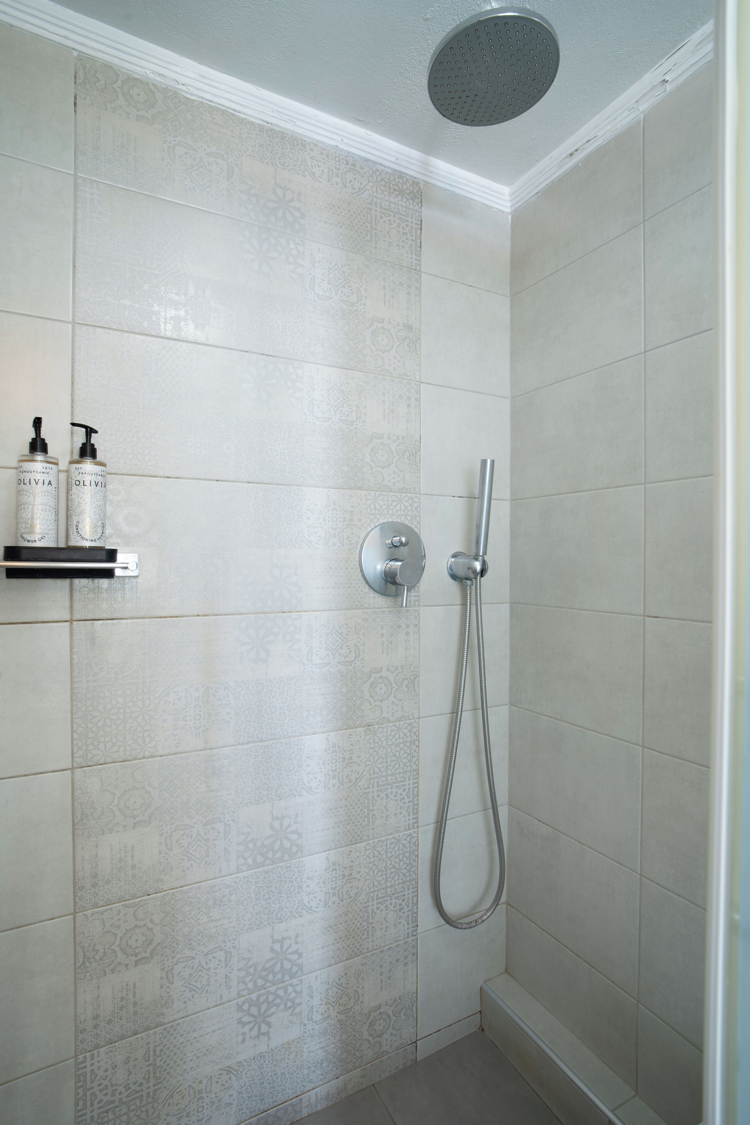 Ducha con cabezal de ducha de mano y grifo empotrado.