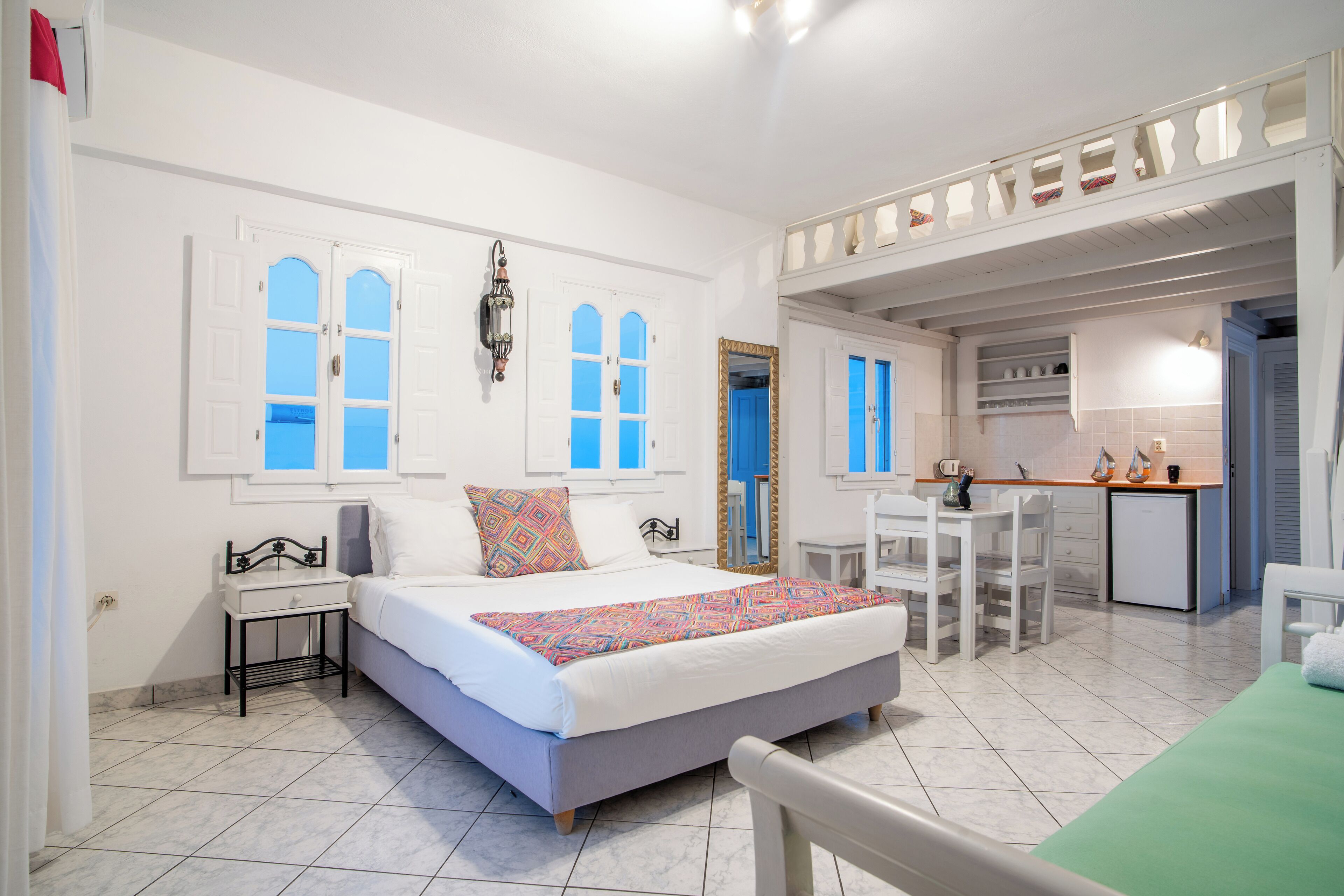 Un dormitorio con cama, mesita de noche y vista a la cocina.