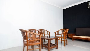 Una habitación con un comedor de madera y un sofá frente a una pared oscura.