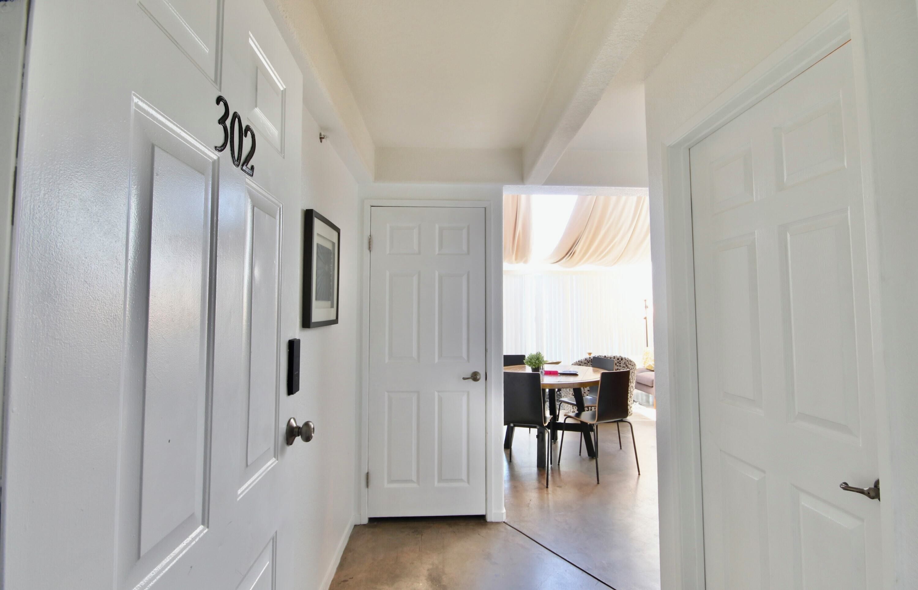 A hallway with white doors, one labeled "302".