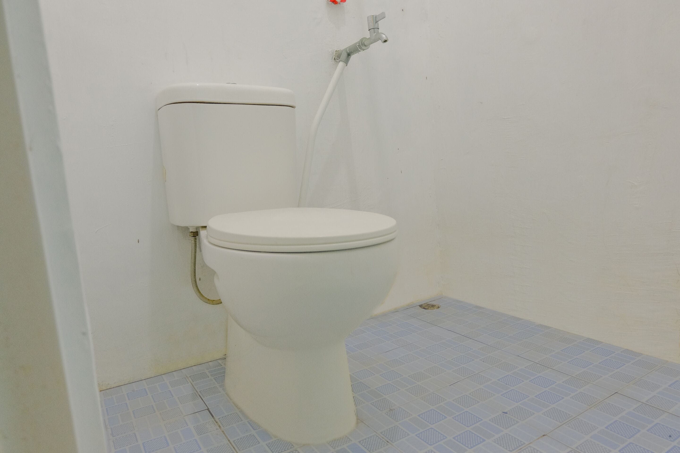 A white toilet with a tank and a flush handle.