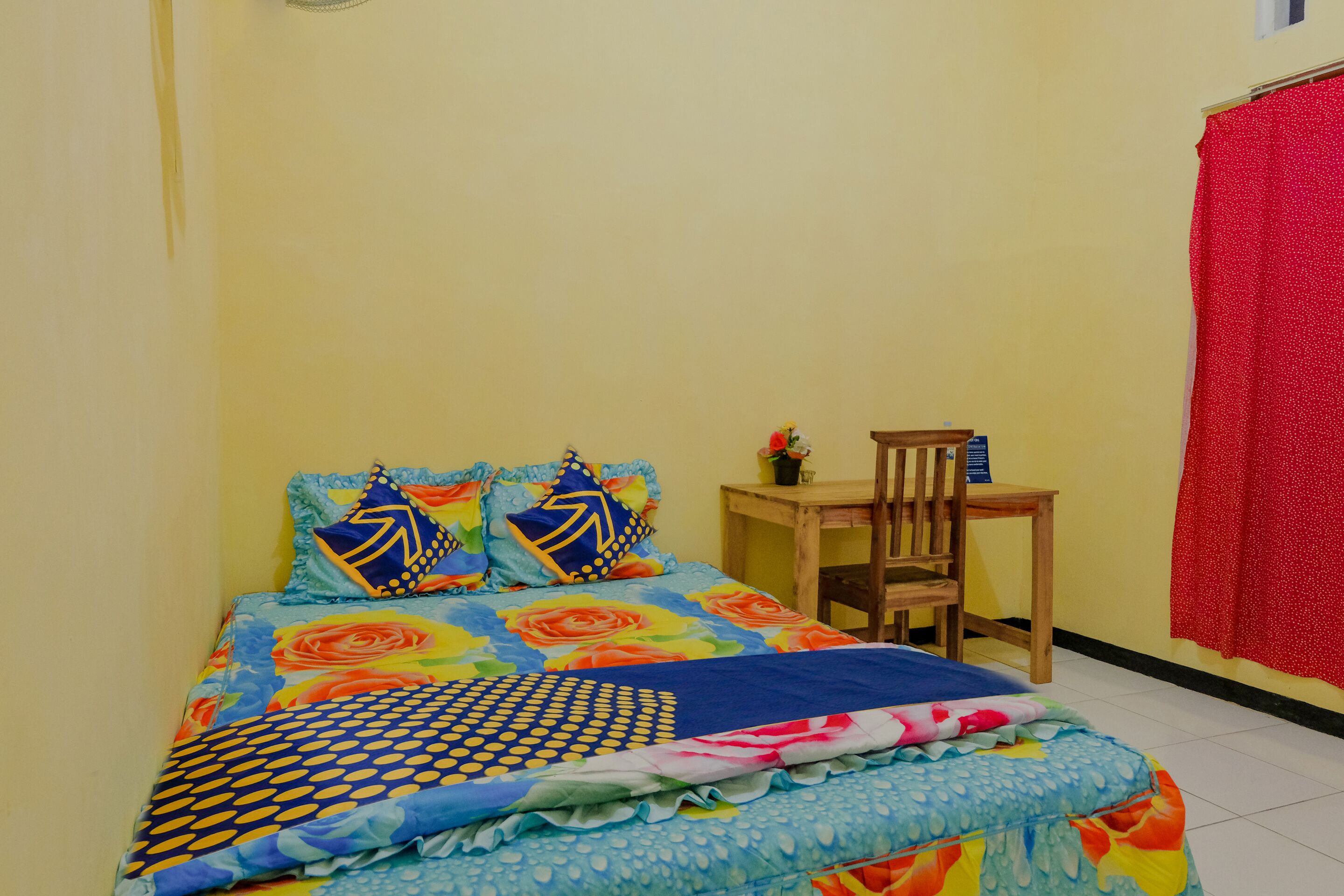 Un dormitorio pequeño y ordenado con cama, una silla y una mesa.