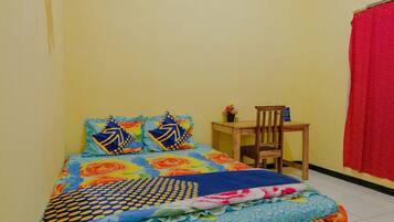 Un dormitorio pequeño y ordenado con cama, una silla y una mesa.