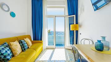 Apartamento panorâmico, 1 quarto, vista para o mar, de frente para o mar | Área de estar | TV de tela plana 32 polegadas com canais digitais, TV