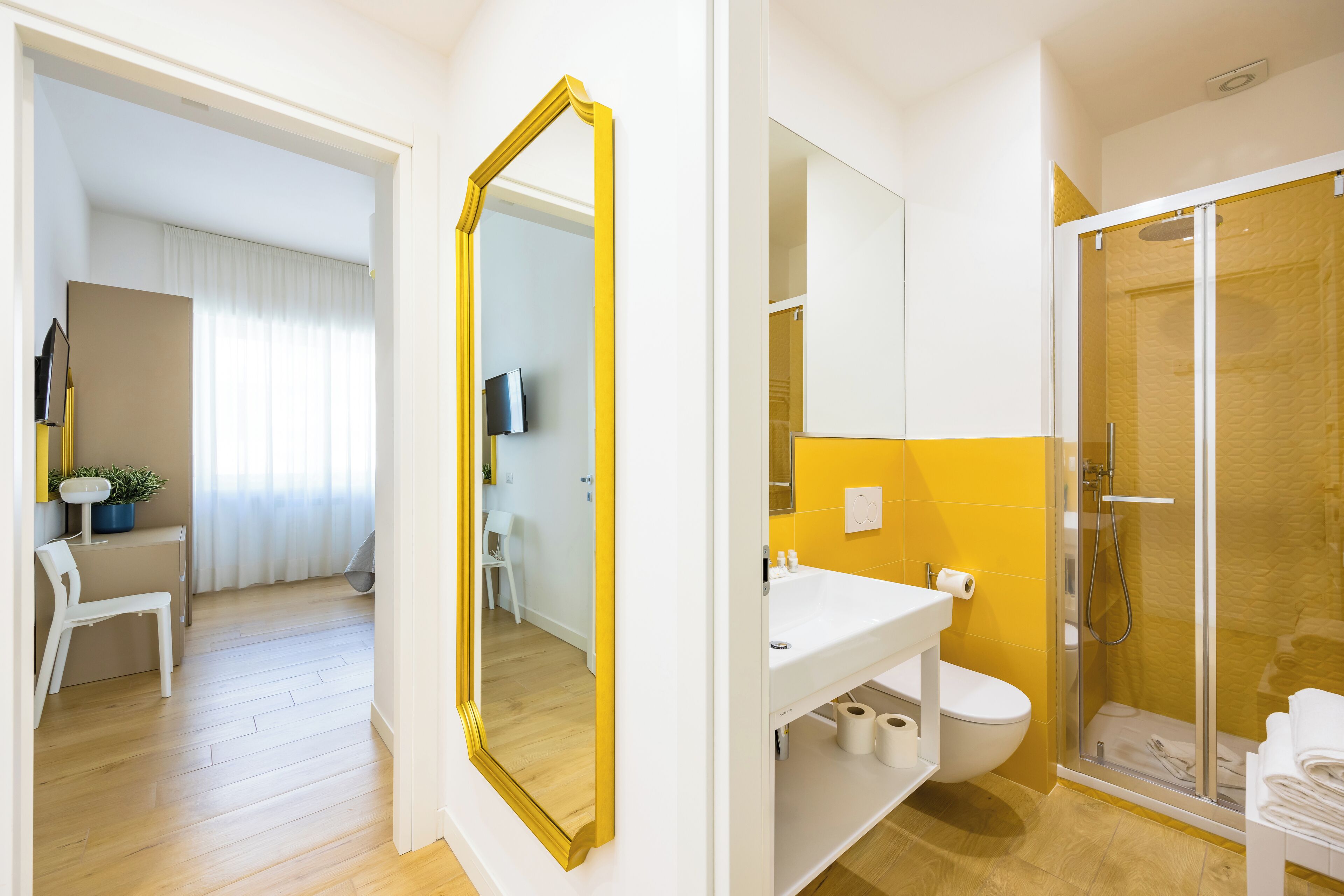 Een moderne badkamer met een douche, toilet en wastafel.