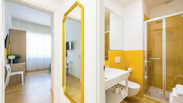 Un baño moderno con ducha, inodoro y lavamanos.