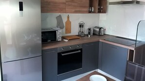 Een moderne keuken met een inbouwoven, magnetron en broodrooster.