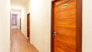 Un couloir avec des portes en bois, chacune portant un numéro.