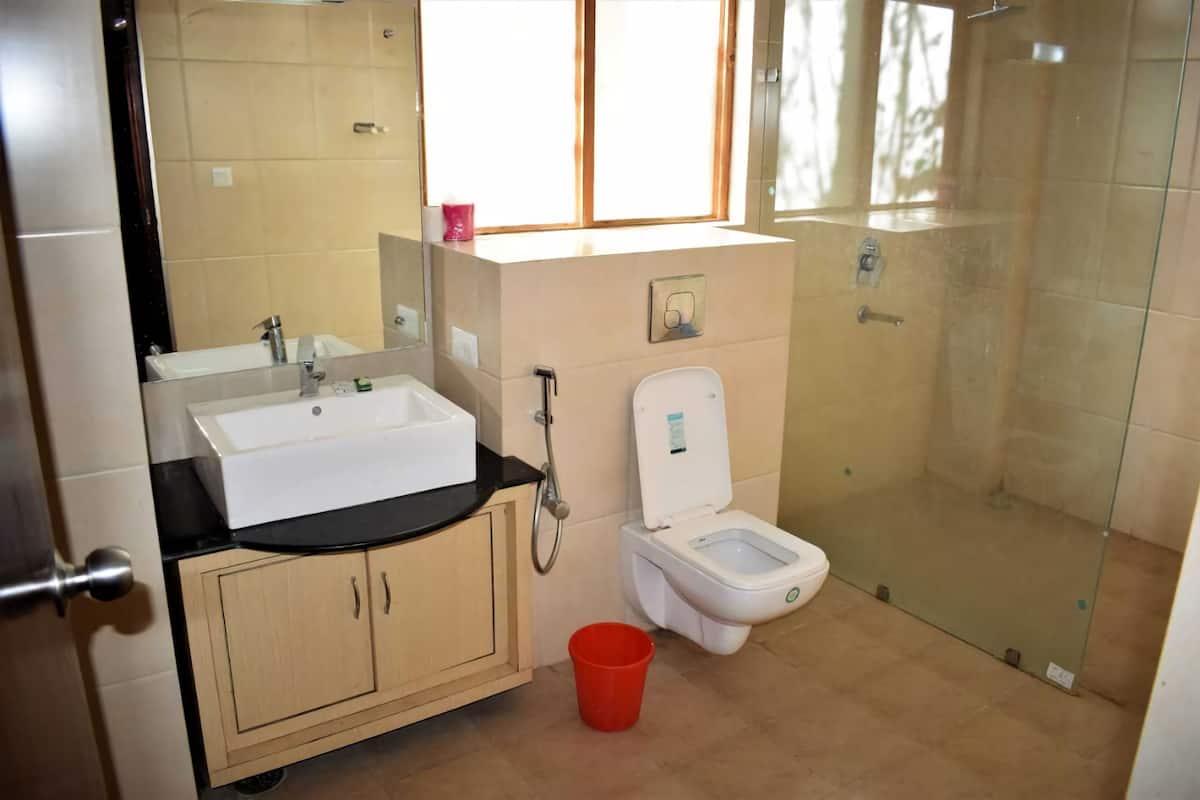 Ein Badezimmer mit Waschbecken, Spiegel, Toilette und Dusche.