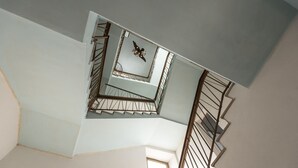 Un interior de varios niveles con una escalera y una lámpara decorativa.