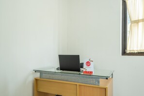 A desk with a laptop, a glass top, and a small box labeled "WHAT'S ON YOUR MIND? LEARNED REVIEW". - OYO 1460 Anyelir Residence (West Cirebon)