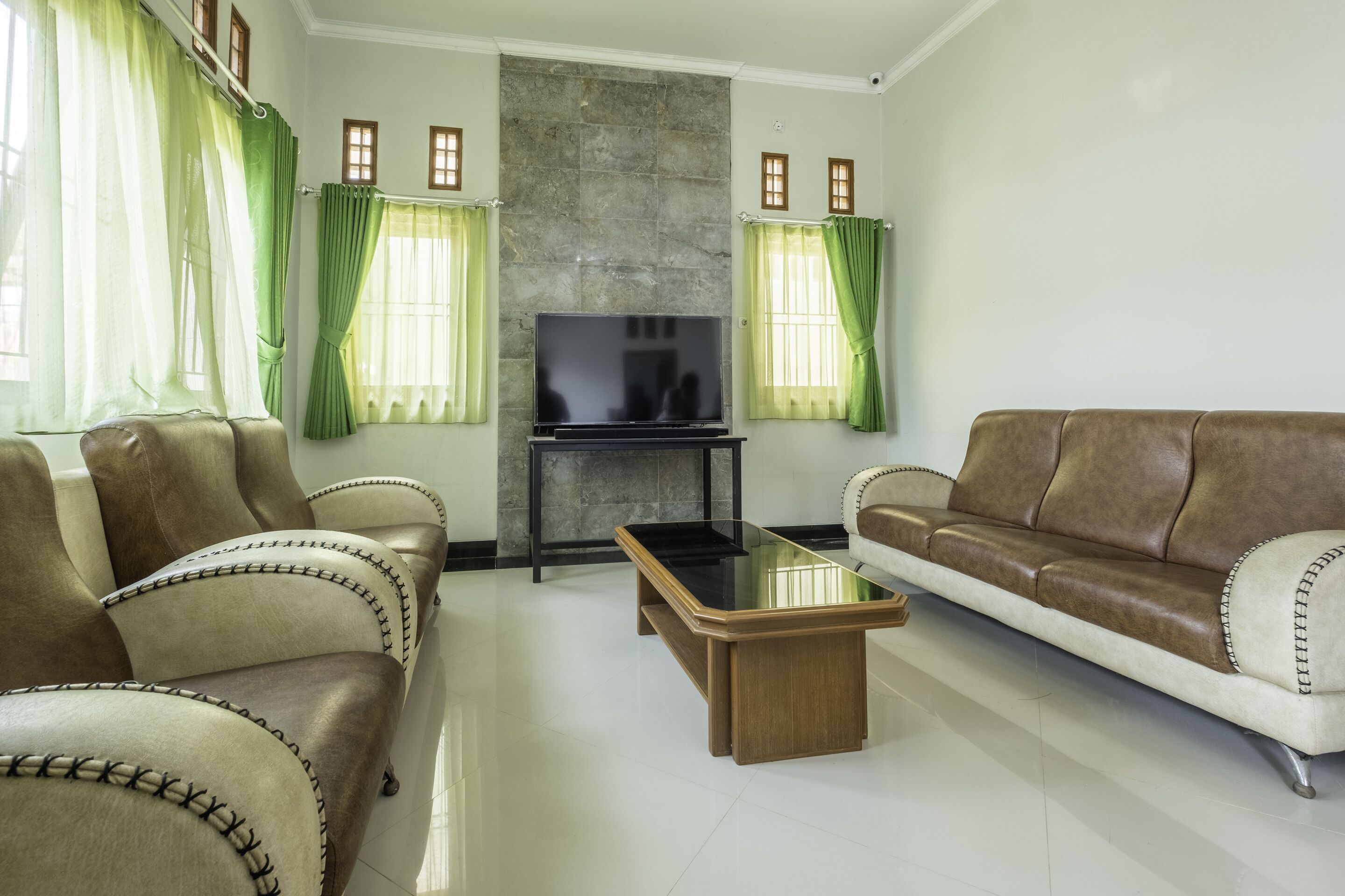 A living room with a sofa, a coffee table, and a television.