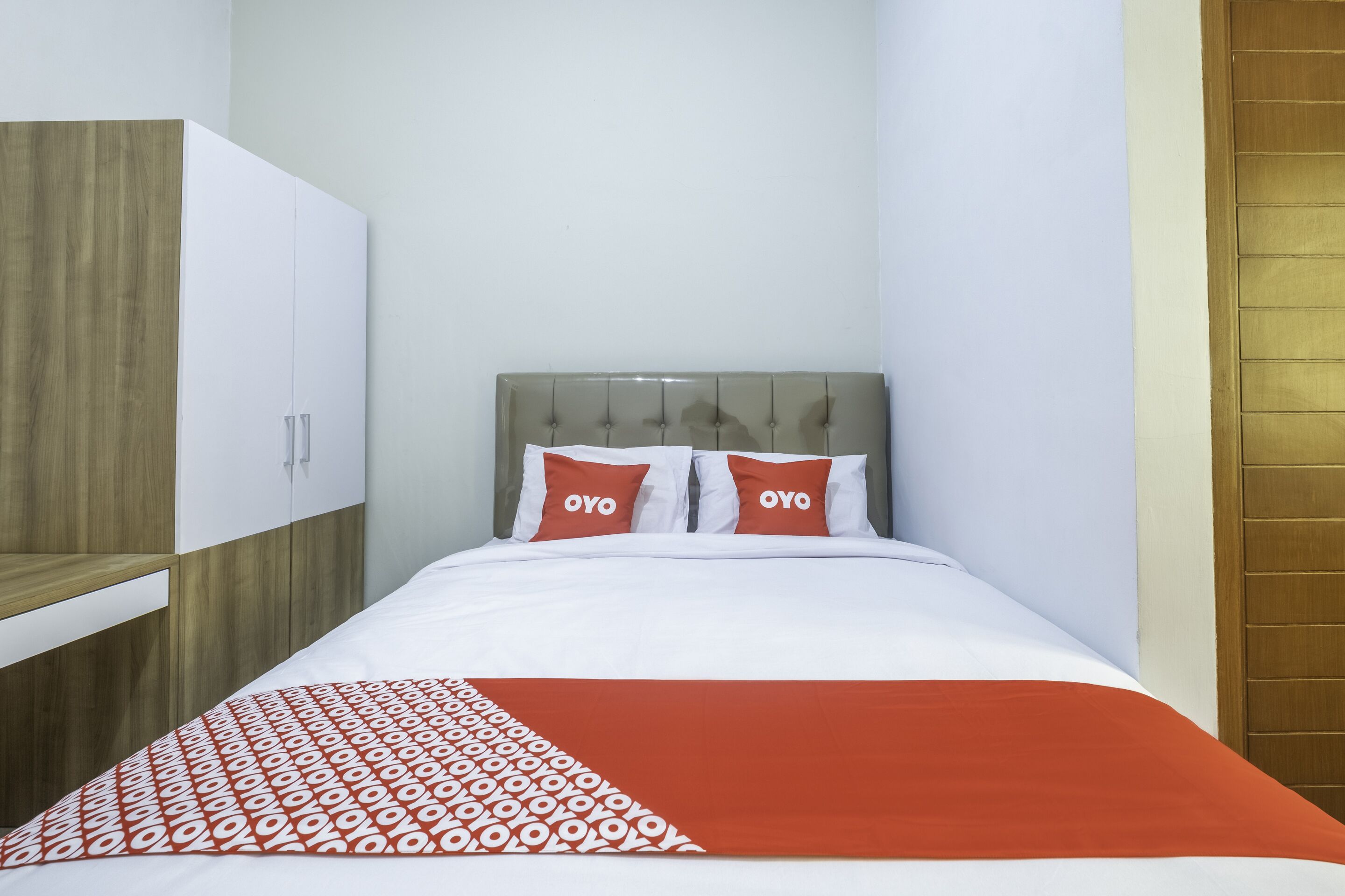 A hotel room with a bed, a wardrobe, and a wooden panel wall.