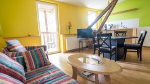 A living room with a sofa, a coffee table, and a dining area with chairs and a table. - FeWo Engler Lüneburg Wallstraße (Lueneburg)