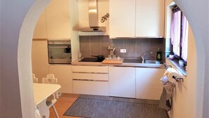 A compact kitchen with a built-in oven, a gas stove, and a sink. - Home near Franklin College and Lugano Center (Collina d'Oro)