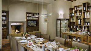 A dining area with a long table set for a meal, surrounded by bookshelves and a wine rack. - Luxury Chianti in La Farfalla (Greve in Chianti)