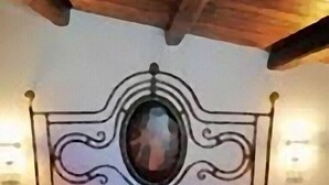 A bed with a metal headboard and a decorative sculpture on the bedspread. - near the sea and the center of San Vito Lo Capo is ideal for families (San Vito Lo Capo)